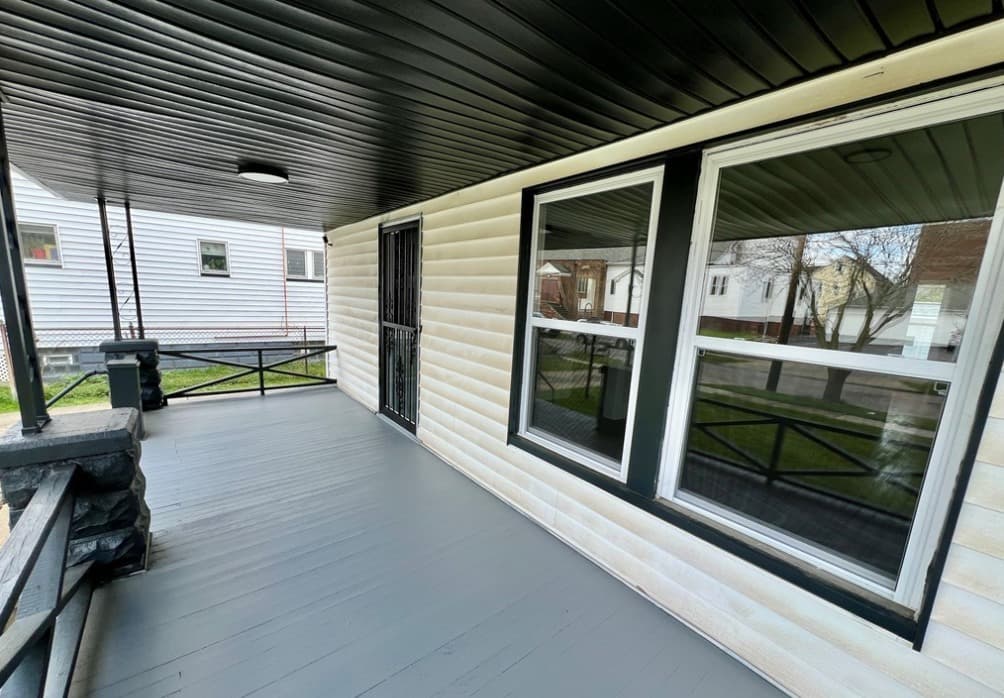 Repaired front porch and replacement windows at the Cleveland project