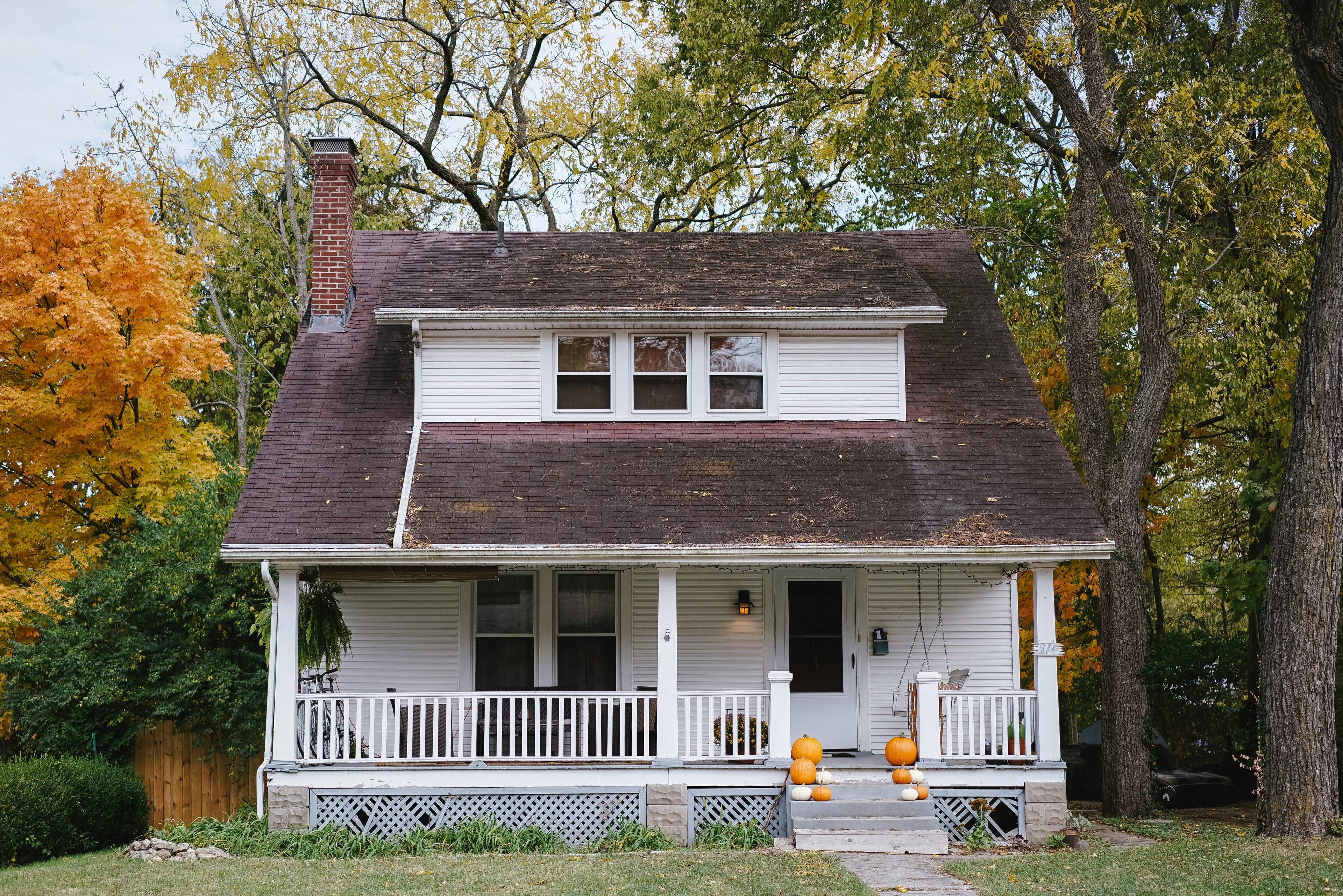Older house with an aging roof and a well-kept front porch